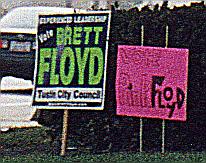 Two campaign signs reading 'Vote Brett Floyd' and 'Vote Pink Floyd'