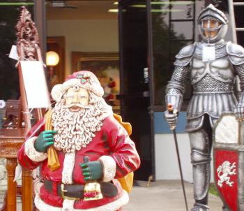 Display outside a shop, includes a Santa Claus statue and a knight-in-armor statue.