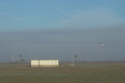 Blimp hangar hidden by fog