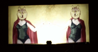 Billboard with two women in swimsuits and red capes with wolf heads.  WTF?