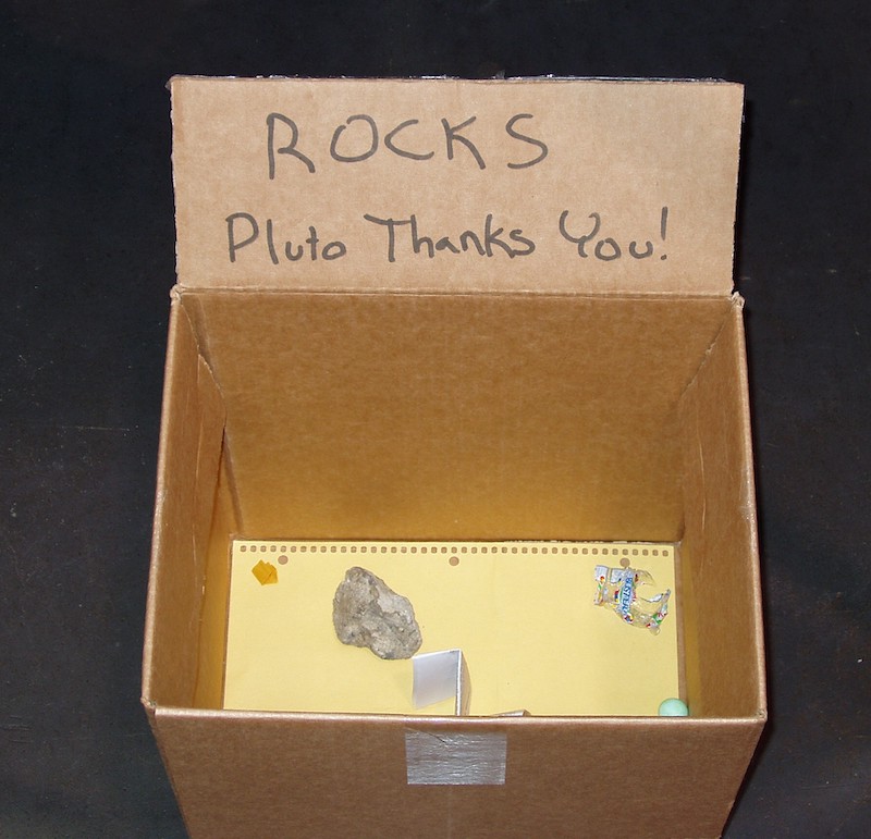 Cardboard box with rocks labeled Pluto thanks you!