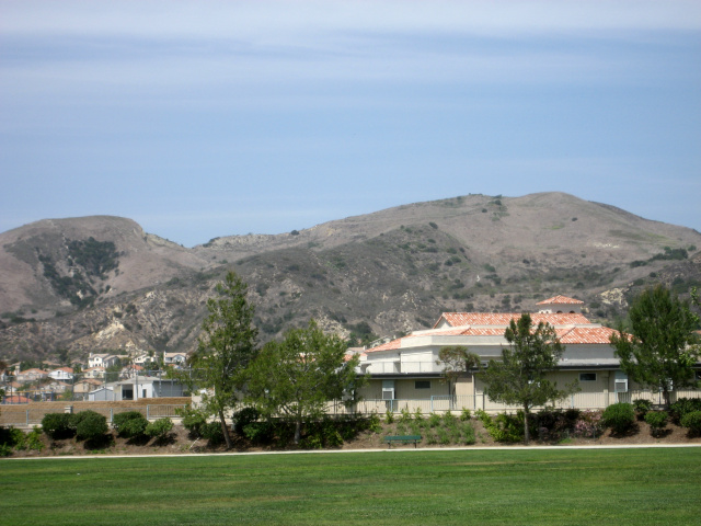 Light brown foothills behind a green lawn.