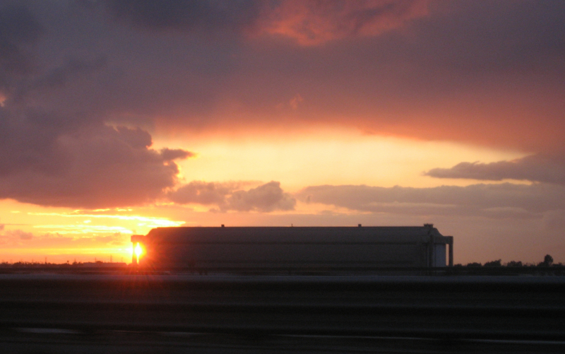 Sunset behind a blimp hangar.