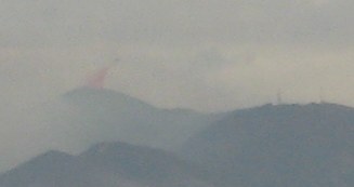 Red flame retardant dropping into the mountains
