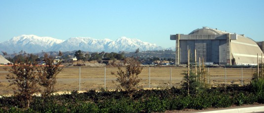 San Gabriels, capped with snow, and blimp hanger in daylight