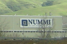 Sign on the wall of an industrial looking building: NUMMI