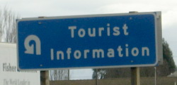 Standing sign for Tourist Information with a near-full-circle arrow on it.