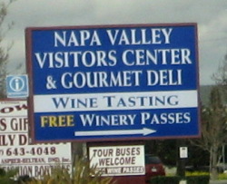 Standing sign: Napa Valley Visitors Center & Gourmet Deli.  Wine Tasting.  Free Winery Passes.