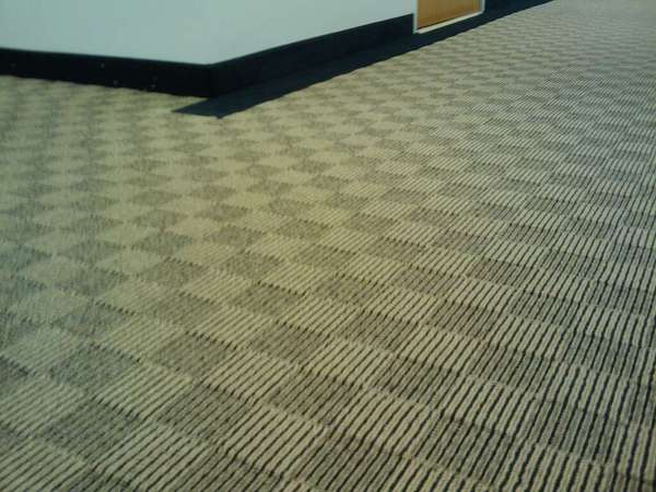 Carpet made up of alternating light and dark squares with pin stripes.