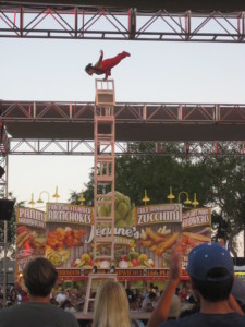 Acrobat balancing on a tower of chairs.