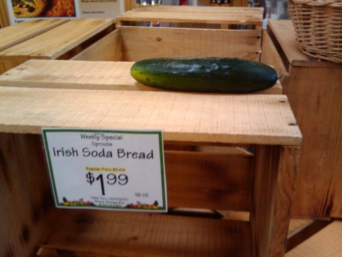 Grocery store sign: Irish Soda Bread. Above it: a cucumber.