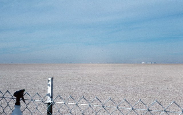 Just a fence and a dry lake bed.