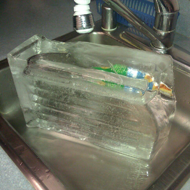 Kitchen sink with a giant block of ice that probably filled an entire drawer.