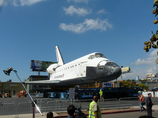 Space Shuttle Endeavour in a parking lot, seen from the front.