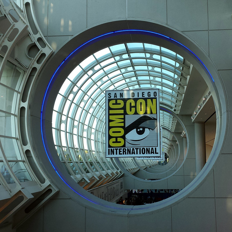 Looking along a long, semi-open tube in a building, with the Comic-Con banner in the center.