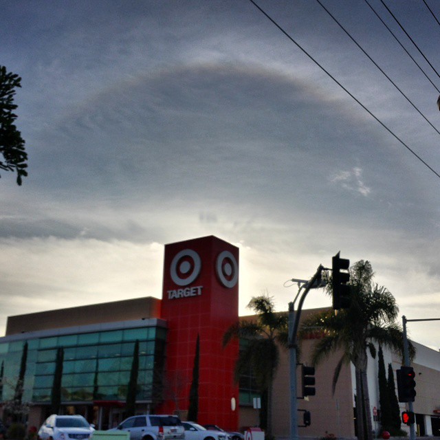 Building with a red tower and the TARGET logo. Above it, a bright circle arcs across the sky, centered behind the bullsye.