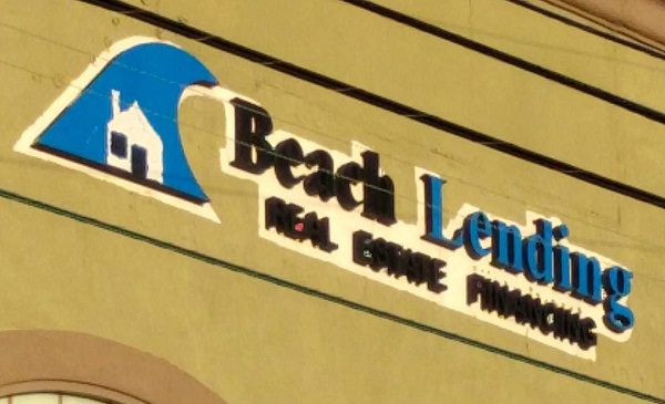 Beach Lending: sign showing an ocean wave with a house inside it.