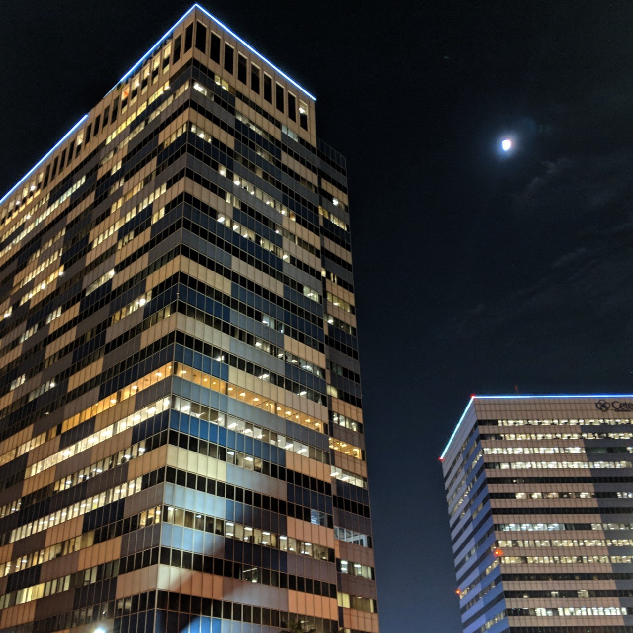 Two high-rise office buildings at night.