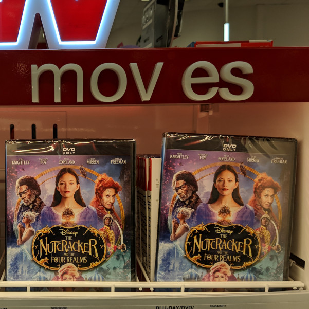 Store shelf with DVDs advertising "MOV ES"
