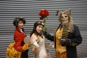 Cosplayers dressed as Gaston, Belle and the Beast from Beauty and the Beast