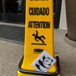 The panda slips in front of a CAUTION sign.