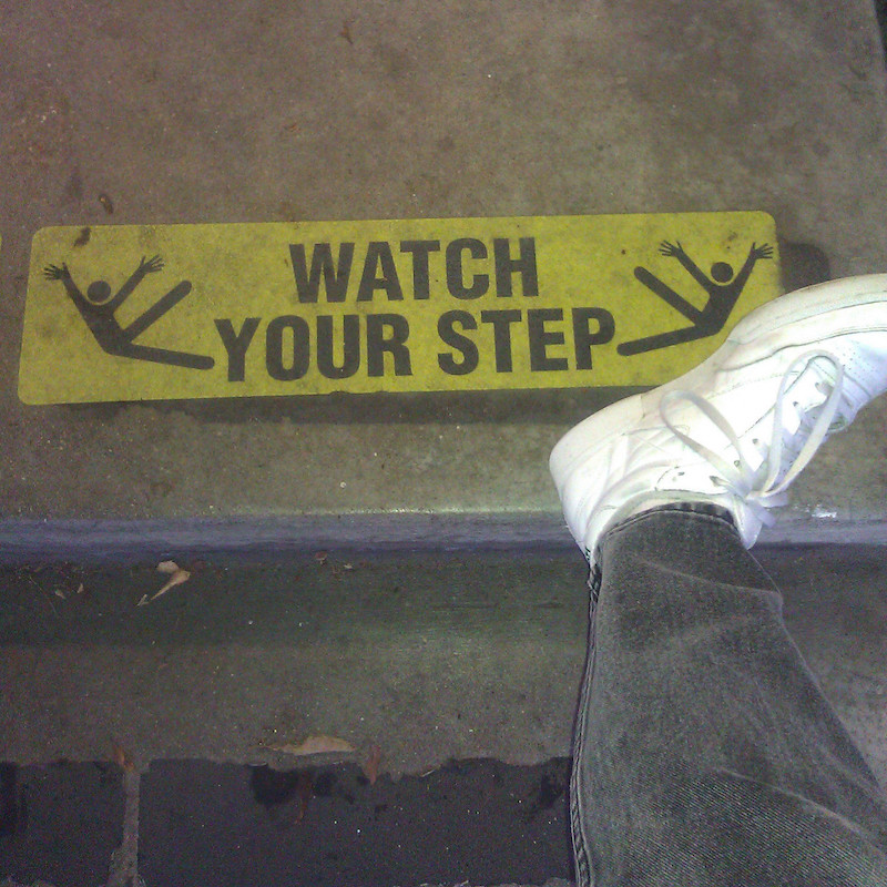 Sign on the floor: Watch your step. (and a foot sticking into the frame)