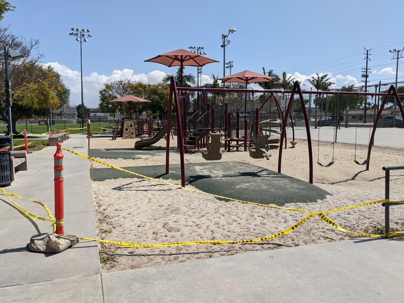 Children's playground with caution tape around it.