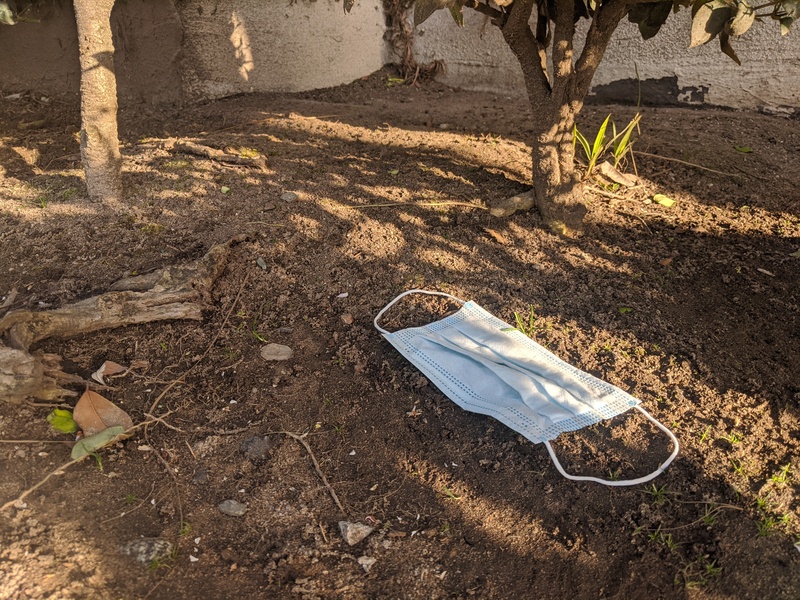 A discarded face mask in the dirt.