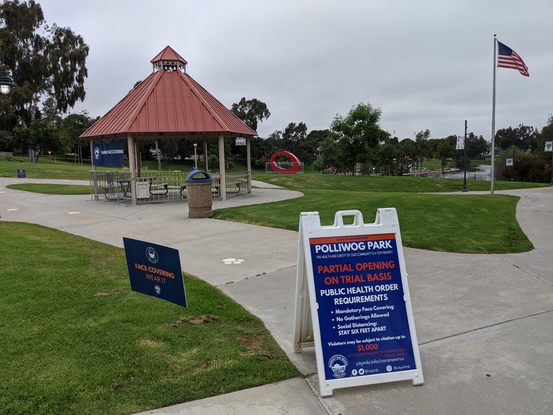 Park with signs for pandemic rules and fences around everything.