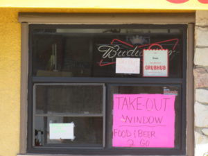 Restaraunt take-out window with sign: Food and  Beer To Go