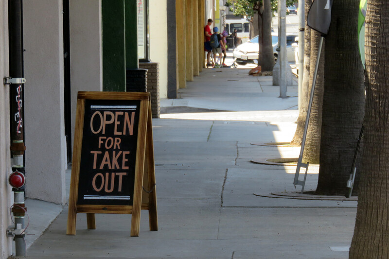 Sign saying Open for Takeout on the sidewalk