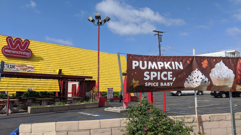 A Wienerschnitzel hot dog restaurant with a banner advertising Pumpkin Spice, Spice, Baby