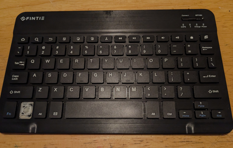 A very flat external computer keyboard (like you would use for a tablet) with one of the Ctrl keys missing.