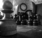Close-up of a chess board from right next to one of the pawns.