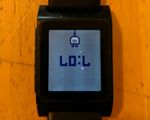 Pebble watch showing 7:07 and a charging icon. Upside-down so it looks like LOL.