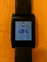 Pebble watch showing 7:07 and a charging icon. Upside-down so it looks like LOL.